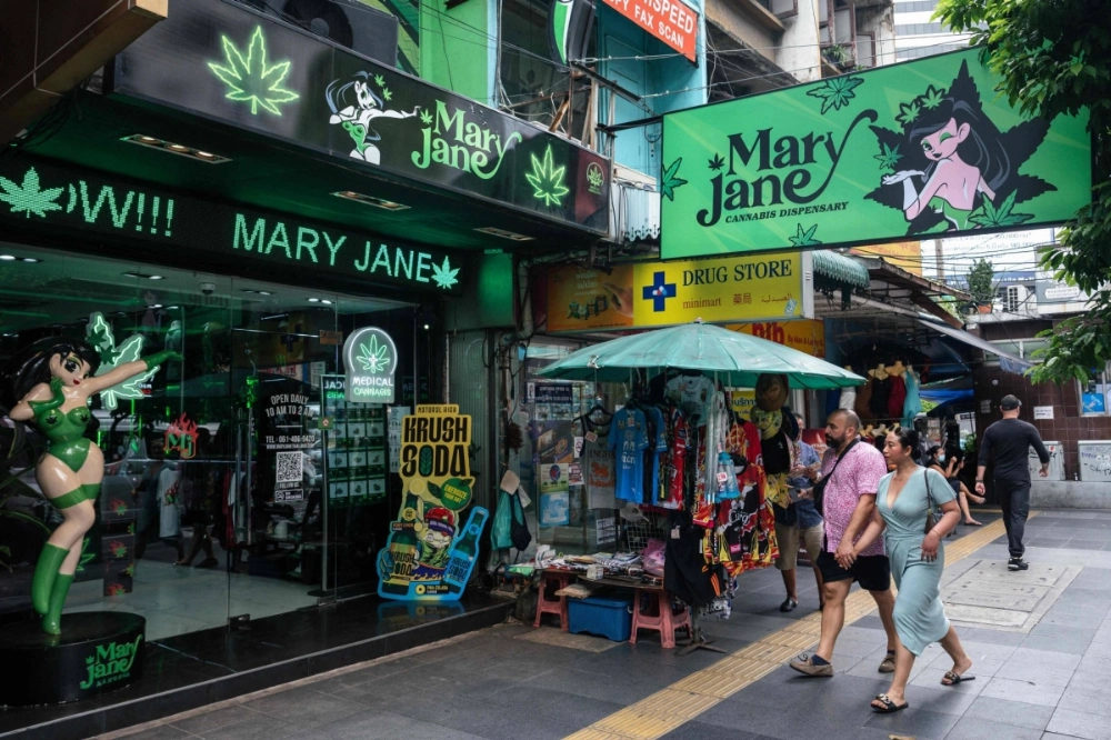 People walk past a cannabis dispensary in Bangkok on Friday. People walk past a cannabis dispensary in Bangkok on Friday.