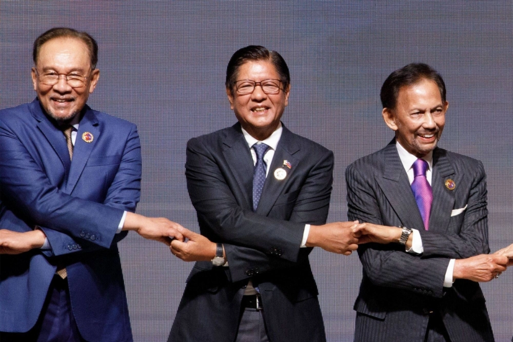 Philippine President Ferdinand Marcos Jr. (center), locks hands with Malaysian Prime Minister Anwar Ibrahim (left) and Sultan of Brunei Hassanal Bolkiah during a group photo at an Association of Southeast Asian Nations summit in Kuala Lumpur on Monday. Philippine President Ferdinand Marcos Jr. (center), locks hands with Malaysian Prime Minister Anwar Ibrahim (left) and Sultan of Brunei Hassanal Bolkiah during a group photo at an Association of Southeast Asian Nations summit in Kuala Lumpur on Monday.