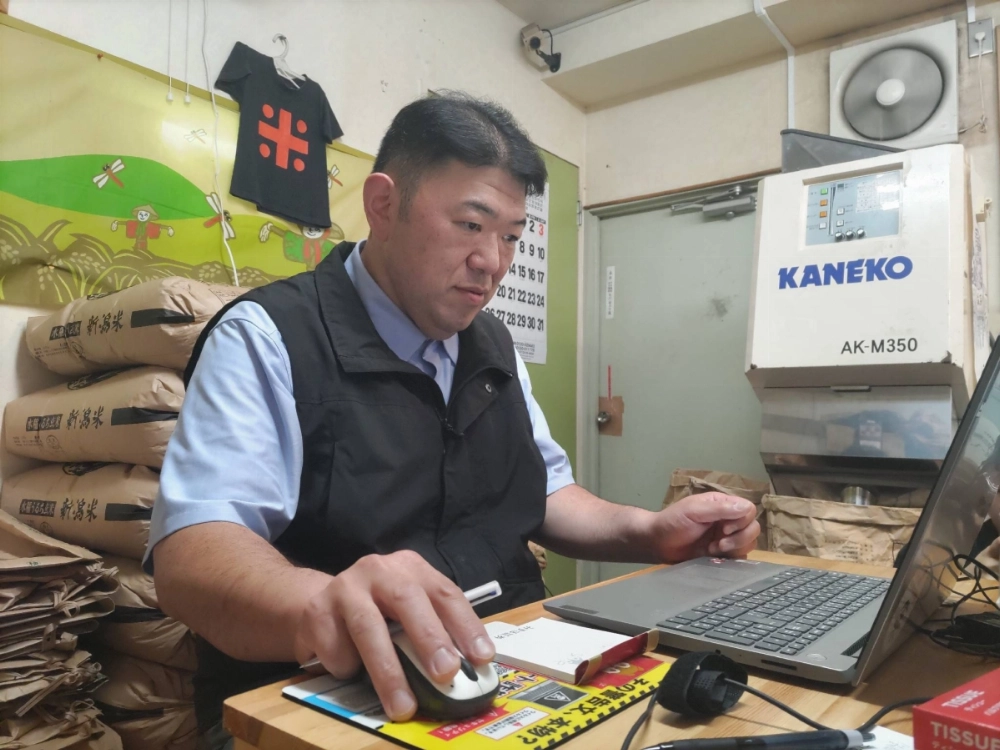 A rice shop owner listens to an online briefing by the farm ministry on the no-bid contract method of purchase for small retailers looking to buy stockpiled rice from the government, on Thursday in Tokyo. A rice shop owner listens to an online briefing by the farm ministry on the no-bid contract method of purchase for small retailers looking to buy stockpiled rice from the government, on Thursday in Tokyo.