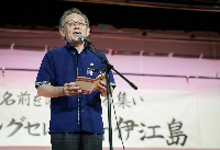 Okinawa Gov. Denny Tamaki speaks during an event held on Ie Island in Okinawa Prefecture on Sunday to read aloud the names of people killed in fierce battles in the prefecture during World War II. | Jiji