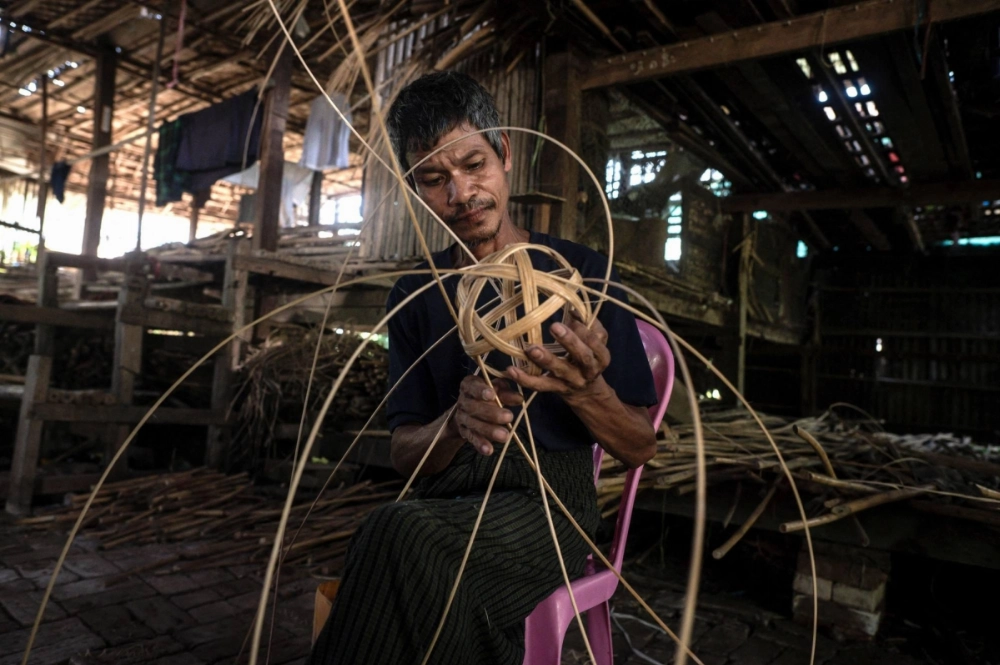 A man weaves cane into a chinlone ball, used in the ancient Myanmar game considered a blend of sport and art, at a workshop in Hinthada township in the Irrawaddy delta region. A man weaves cane into a chinlone ball, used in the ancient Myanmar game considered a blend of sport and art, at a workshop in Hinthada township in the Irrawaddy delta region.