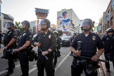 Police in riot gear stand near a mural of Dodgers star Shohei Ohtani during protests against federal immigration raids in Los Angeles’s Little Tokyo neighborhood on Monday. Police in riot gear stand near a mural of Dodgers star Shohei Ohtani during protests against federal immigration raids in Los Angeles’s Little Tokyo neighborhood on Monday.