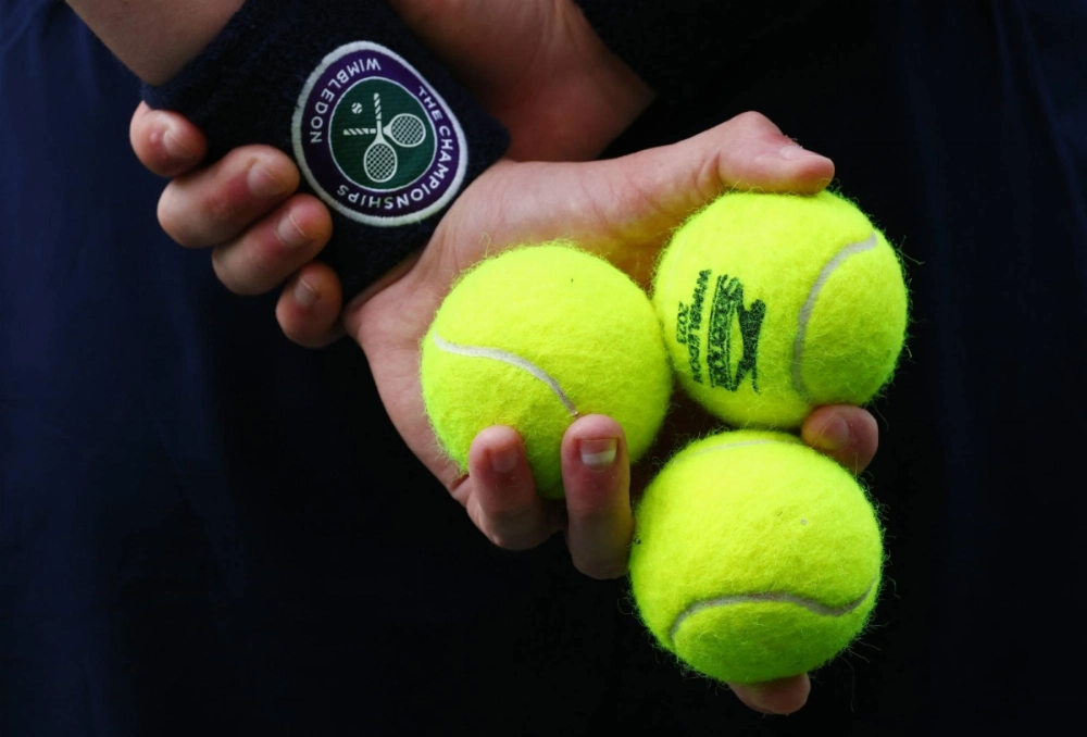 A ball kid holds tennis balls during a women's quarterfinal match at Wimbledon in July 2023.
  A ball kid holds tennis balls during a women's quarterfinal match at Wimbledon in July 2023.