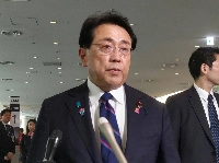 Japan’s top trade negotiator Ryosei Akazawa speaks to reporters Friday at Haneda Airport in Tokyo before heading to Washington. | Jiji