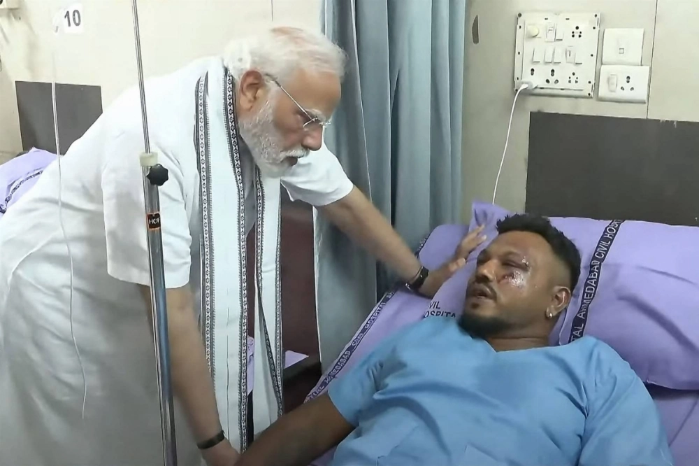 Indian Prime Minister Narendra Modi meets with Vishwash Kumar Ramesh, the sole survivor of the crash of Air India Flight 171, at a hospital in Ahmedabad, India, on Friday in this image taken from a video. Indian Prime Minister Narendra Modi meets with Vishwash Kumar Ramesh, the sole survivor of the crash of Air India Flight 171, at a hospital in Ahmedabad, India, on Friday in this image taken from a video.