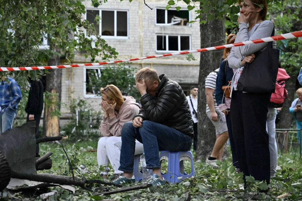Residents react as Ukrainian rescuers conduct a search after a Russian missile strike in Kyiv on Tuesday. Residents react as Ukrainian rescuers conduct a search after a Russian missile strike in Kyiv on Tuesday.