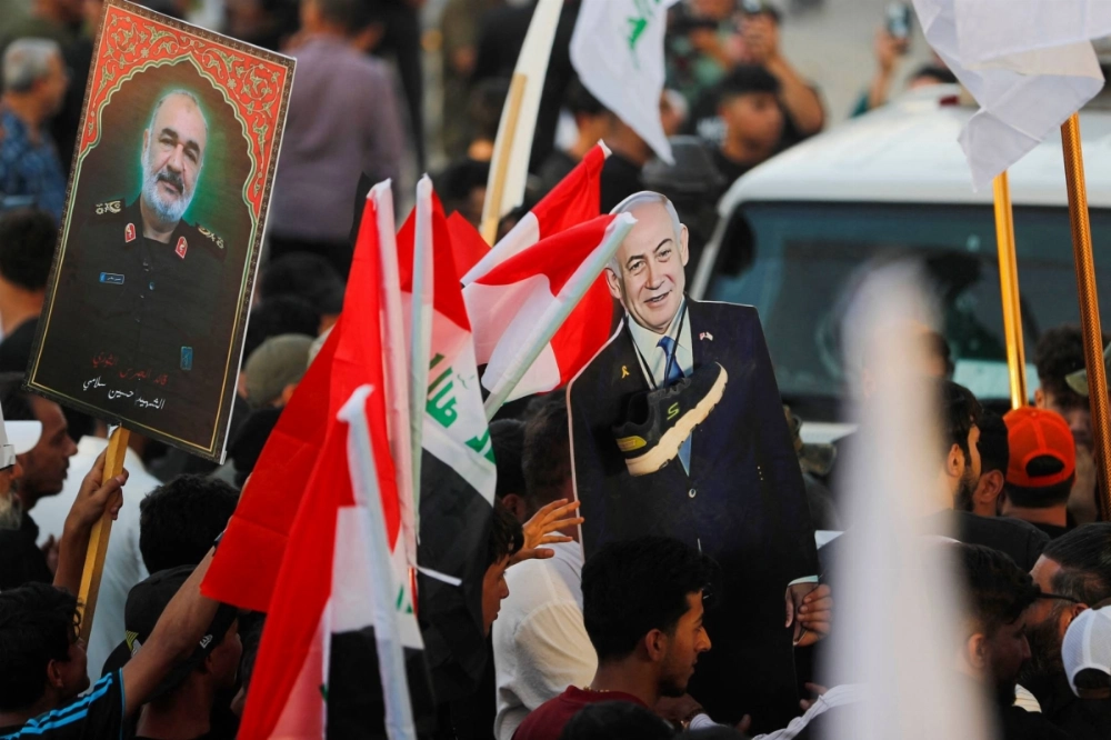 A picture of Major Gen. Hossein Salami (left), head of the Iranian Revolutionary Guard, who was killed in an Israeli airstrike in Tehran and a cutout of Israeli Prime Minister Benjamin Netanyahu during a protest in support of Iran, in Baghdad on Monday A picture of Major Gen. Hossein Salami (left), head of the Iranian Revolutionary Guard, who was killed in an Israeli airstrike in Tehran and a cutout of Israeli Prime Minister Benjamin Netanyahu during a protest in support of Iran, in Baghdad on Monday