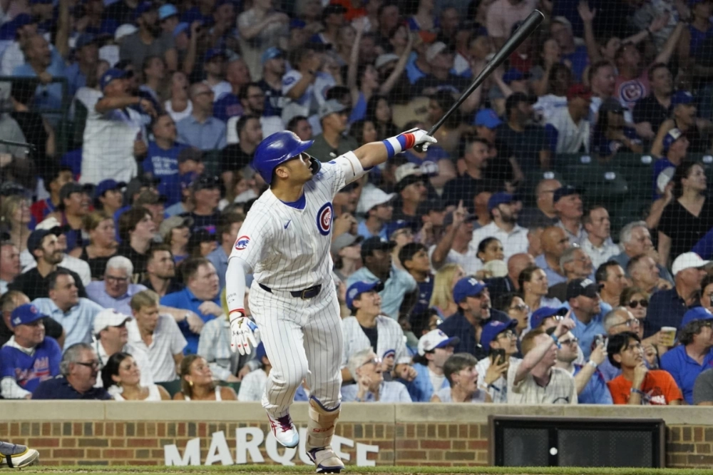Cubs designated hitter Seiya Suzuki hits a three-run home run against the Brewers at Wrigley Field in Chicago on Tuesday.  Cubs designated hitter Seiya Suzuki hits a three-run home run against the Brewers at Wrigley Field in Chicago on Tuesday.