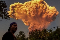 A man watches the eruption of Mount Lewotobi Laki-Laki as seen from East Nusa Tenggara, Bali, Indonesia, on Tuesday. | AFP-JIJI