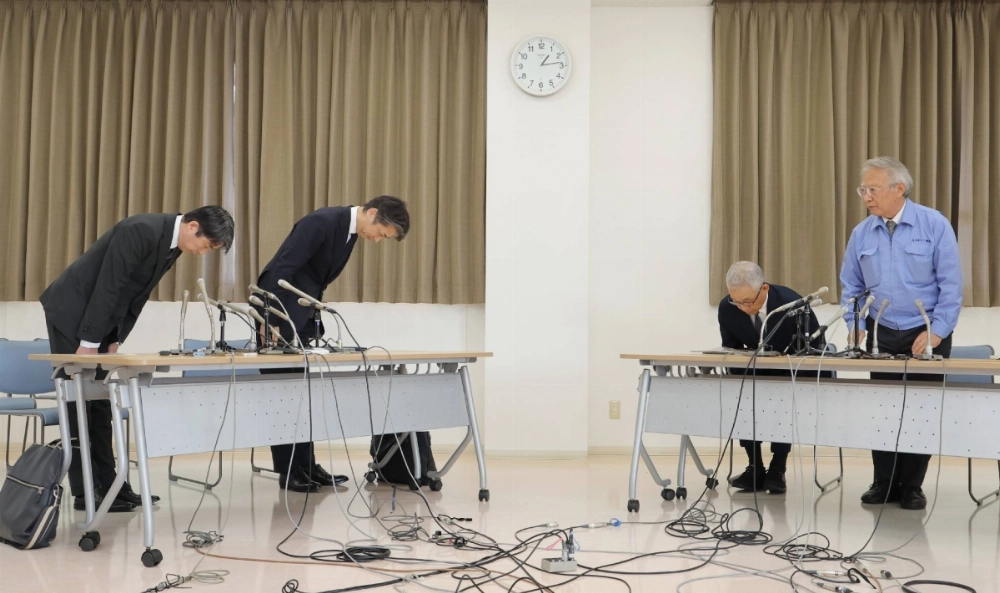 Hirohide Mori (left), head of the Tokyo District Public Prosecutor's Office's public security division, and Tetsuro Kamata, deputy superintendent-general of Tokyo's Metropolitan Police Department, bow toward former Ohkawara Kakohki executive Junji Shimada (second from right) and company President Masaaki Okawara on Friday in Yokohama.  Hirohide Mori (left), head of the Tokyo District Public Prosecutor's Office's public security division, and Tetsuro Kamata, deputy superintendent-general of Tokyo's Metropolitan Police Department, bow toward former Ohkawara Kakohki executive Junji Shimada (second from right) and company President Masaaki Okawara on Friday in Yokohama.