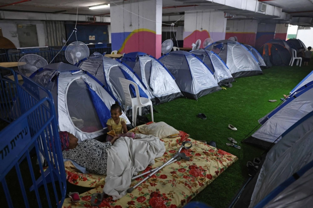 People sit outside pitched tents as they take shelter at a bus station in Tel Aviv on Saturday amid fears of an Iranian missile attack. People sit outside pitched tents as they take shelter at a bus station in Tel Aviv on Saturday amid fears of an Iranian missile attack.