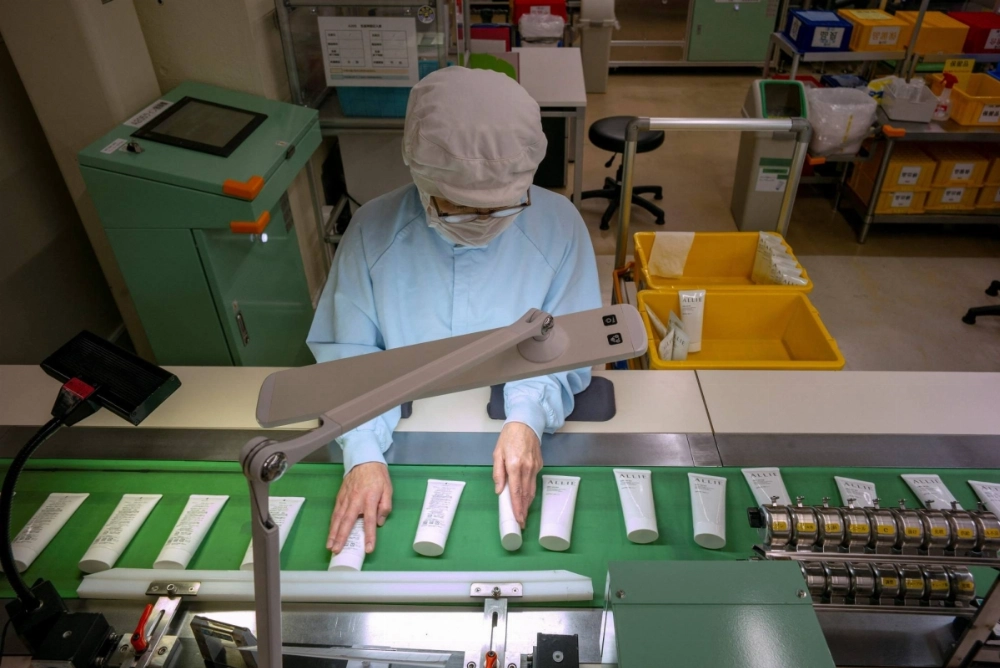 A worker checks sunscreen products during the final manufacturing process at a factory for the Japanese chemical and cosmetics company Kao in Odawara, Kanagawa Prefecture.  A worker checks sunscreen products during the final manufacturing process at a factory for the Japanese chemical and cosmetics company Kao in Odawara, Kanagawa Prefecture.