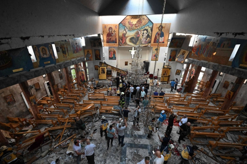 People and rescuers inspect the damage at the site of a reported suicide attack at the Saint Elias church in Damascus on Sunday. People and rescuers inspect the damage at the site of a reported suicide attack at the Saint Elias church in Damascus on Sunday.