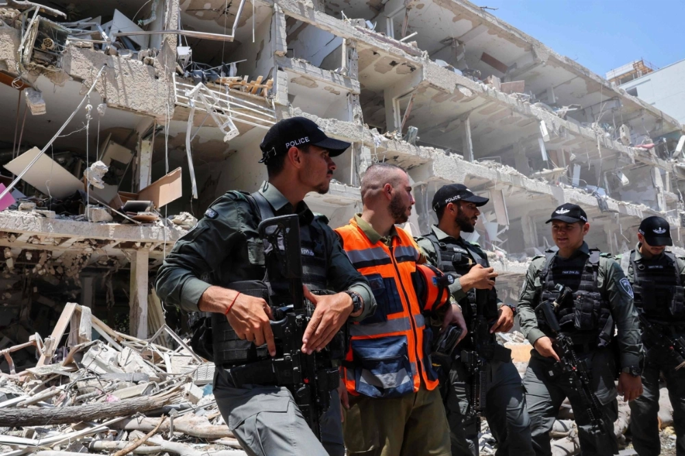 Israeli security forces stand guard at the site of an Iranian strike on a residential neighborhood in the Ramat Aviv area of Tel Aviv on Sunday. Israeli security forces stand guard at the site of an Iranian strike on a residential neighborhood in the Ramat Aviv area of Tel Aviv on Sunday.