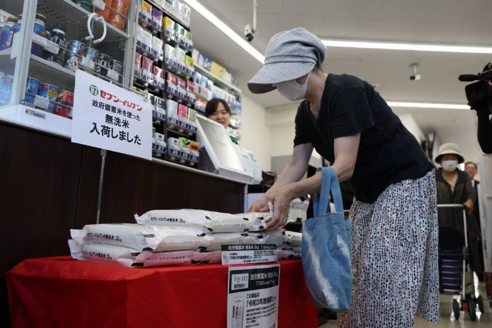 A customer picks up a bag of government-stockpiled rice sold at a convenience store in Tokyo. A customer picks up a bag of government-stockpiled rice sold at a convenience store in Tokyo.