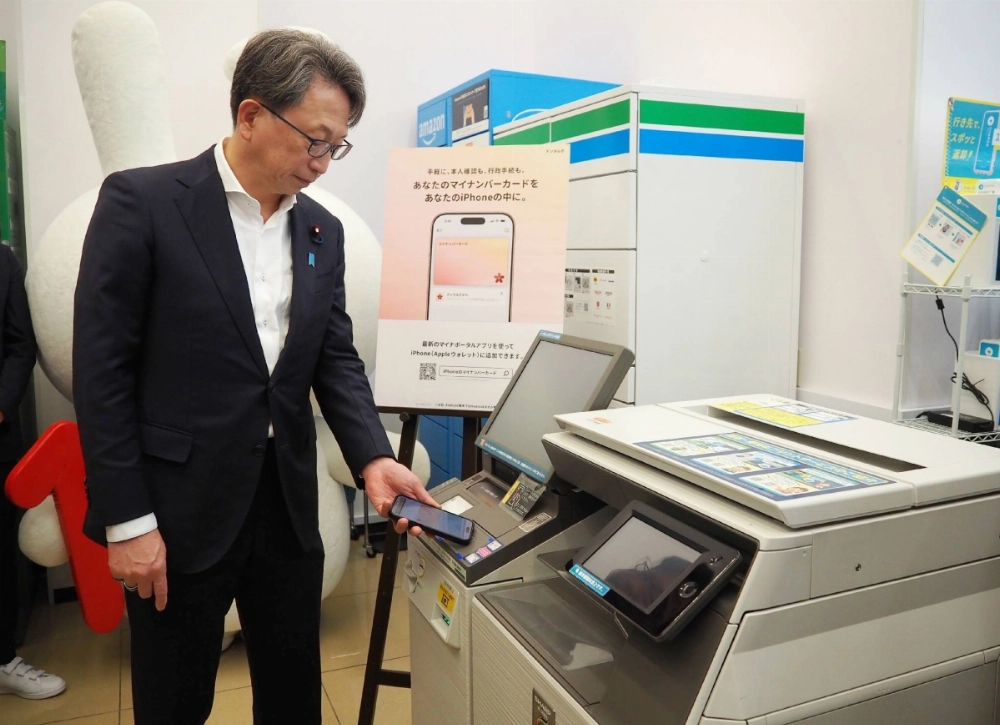 Digital transformation minister Masaaki Taira obtains a certification document using a My Number personal identification card installed on an iPhone in Tokyo on Tuesday. Digital transformation minister Masaaki Taira obtains a certification document using a My Number personal identification card installed on an iPhone in Tokyo on Tuesday.