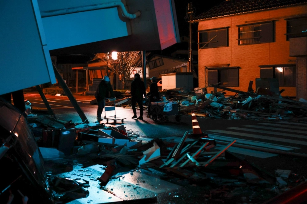 People push a cart to receive water to distribute to neighbors in Wajima, Ishikawa Prefecture, on Jan. 5, 2024, after a massive earthquake hit the area. People push a cart to receive water to distribute to neighbors in Wajima, Ishikawa Prefecture, on Jan. 5, 2024, after a massive earthquake hit the area.