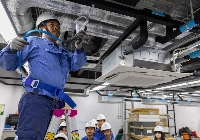 An employee of Daikin Cambodia demonstrates the use of a safety harness during an air conditioner installation training session in Phnom Penh. | ANTON L. Delgado