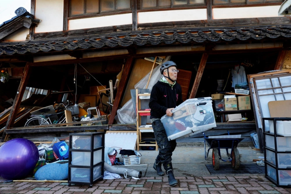 A resident carries his belongings from his damaged house in Nanao, Ishikawa Prefecture, on Jan. 2, 2024 — the day after a major earthquake devastated parts of the area. A resident carries his belongings from his damaged house in Nanao, Ishikawa Prefecture, on Jan. 2, 2024 — the day after a major earthquake devastated parts of the area.