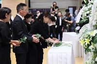 Bereaved families of the victims of the 2020 Kumamoto rain and flooding disaster lay flowers at a memorial held in Hitoyoshi, Kumamoto Prefecture, on Sunday. | Jiji