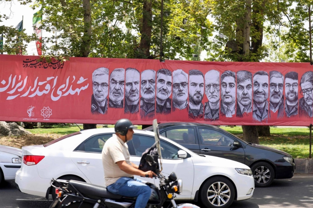 Traffic moves past a large banner depicting Iranian commanders and scientists killed in Israeli strikes during the 12-day war between Iran and Israel, at Tajrish Square in the capital Tehran on Monday. Traffic moves past a large banner depicting Iranian commanders and scientists killed in Israeli strikes during the 12-day war between Iran and Israel, at Tajrish Square in the capital Tehran on Monday.