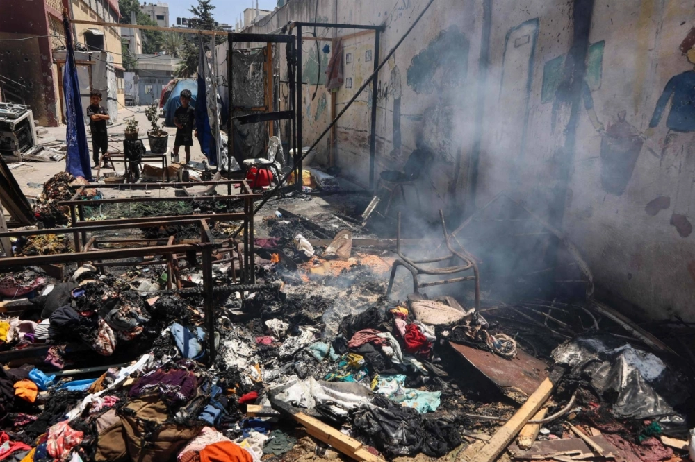 Children look at smoldering debris at Mustafa Hafez school, which sheltered Palestinians displaced by the war, following an overnight Israeli strike in Gaza City, on Thursday. Children look at smoldering debris at Mustafa Hafez school, which sheltered Palestinians displaced by the war, following an overnight Israeli strike in Gaza City, on Thursday.