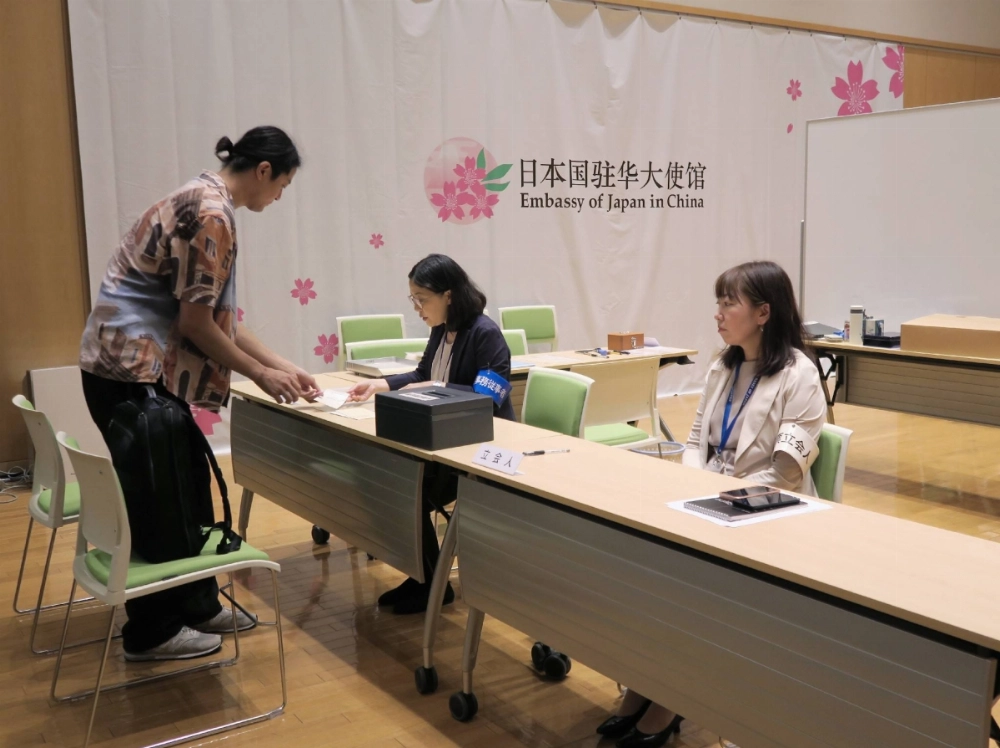 A voter casts a ballot for the Upper House election at the Japanese Embassy in Beijing on Friday.  A voter casts a ballot for the Upper House election at the Japanese Embassy in Beijing on Friday.