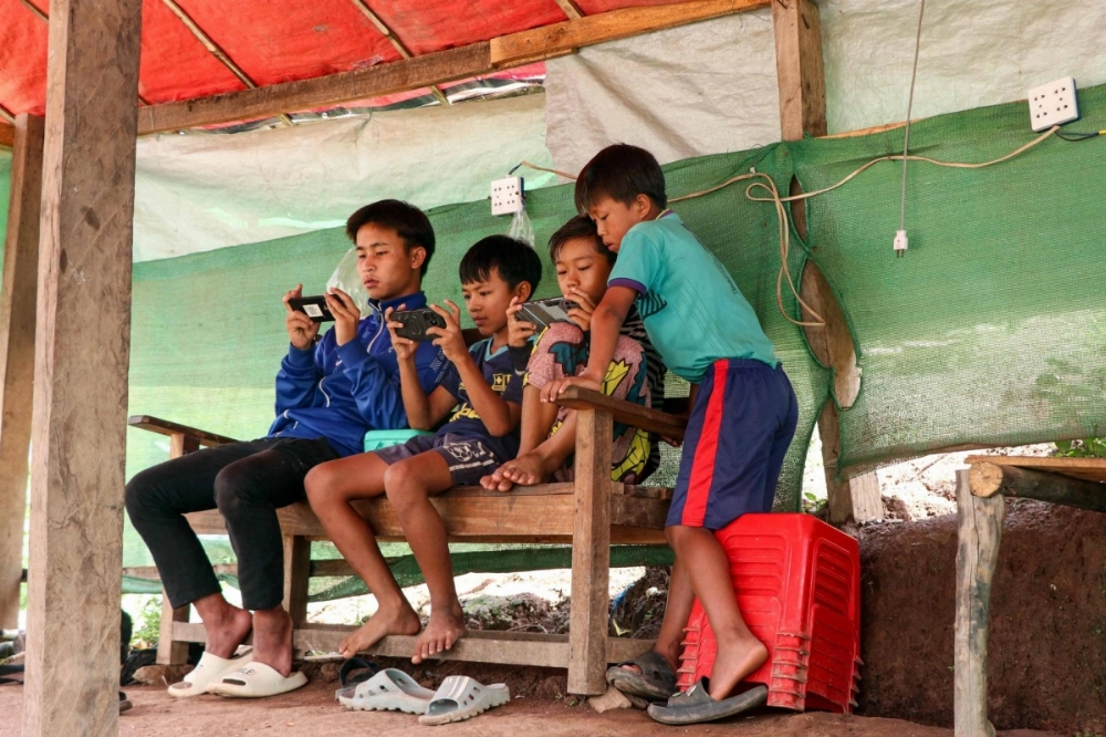 Children play video games on their mobile phones at an internet cafe in Demoso township in Myanmar's eastern Karenni state.  Children play video games on their mobile phones at an internet cafe in Demoso township in Myanmar's eastern Karenni state.