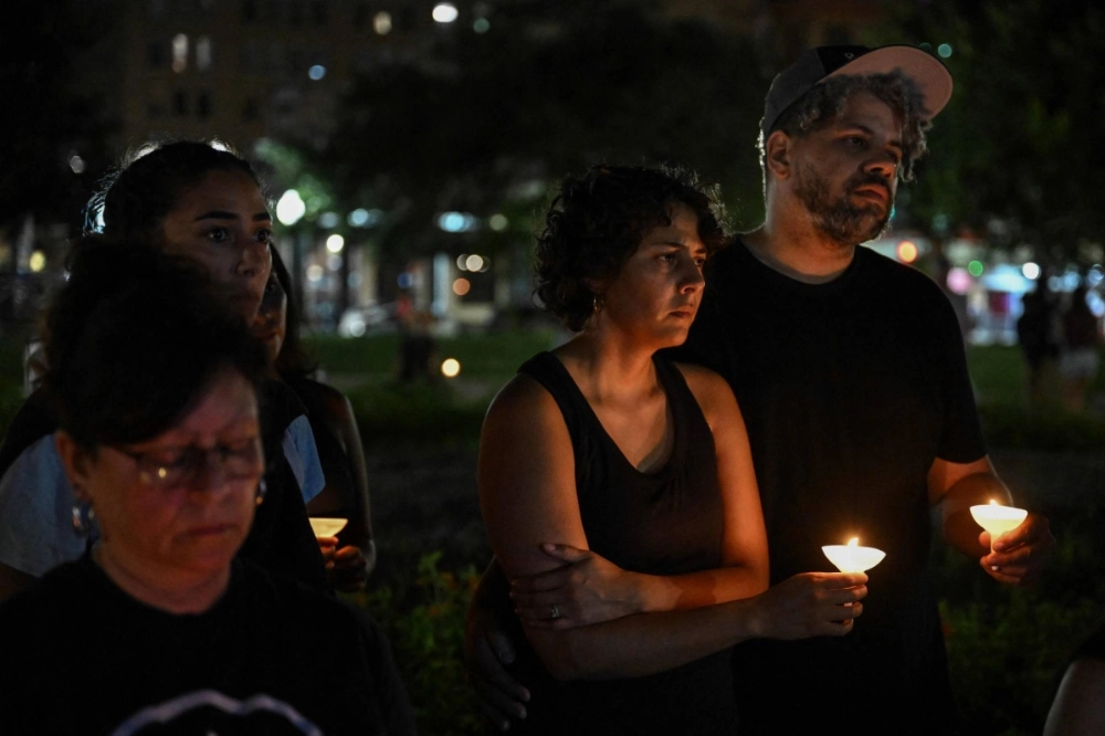 People hold candles as they take part in a vigil for the victims of the floods over Fourth of July weekend, at Travis Park, in San Antonio, Texas, on Monday. People hold candles as they take part in a vigil for the victims of the floods over Fourth of July weekend, at Travis Park, in San Antonio, Texas, on Monday.