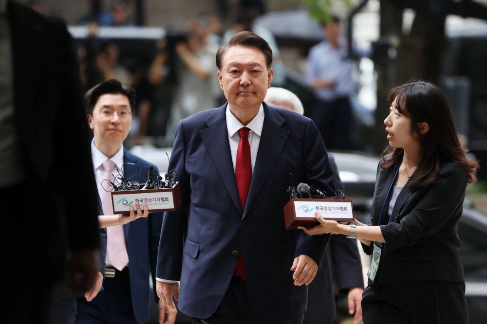 Impeached former South Korean President Yoon Suk Yeol (center) arrives for a court hearing to review a new arrest warrant requested by special prosecutors in Seoul on Wednesday. Impeached former South Korean President Yoon Suk Yeol (center) arrives for a court hearing to review a new arrest warrant requested by special prosecutors in Seoul on Wednesday.