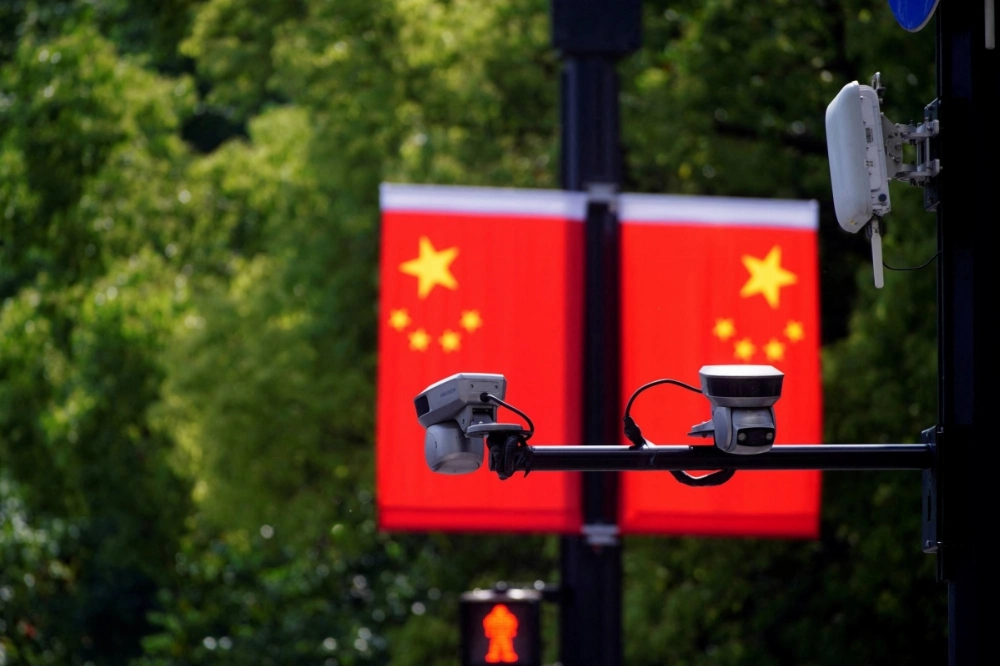 Surveillance cameras are seen in front of a Chinese flag near a shopping area in Shanghai in 2021. Beijing has stepped up espionage warnings in recent years amid worsening relations with the United States and other Western nations. Surveillance cameras are seen in front of a Chinese flag near a shopping area in Shanghai in 2021. Beijing has stepped up espionage warnings in recent years amid worsening relations with the United States and other Western nations.