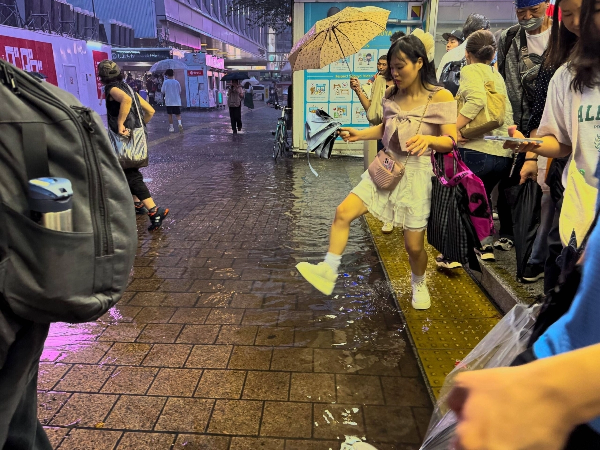 Commuters in Tokyo's Shibuya make their way around puddle from sudden heavy rain on Thursday evening. Commuters in Tokyo's Shibuya make their way around puddle from sudden heavy rain on Thursday evening.