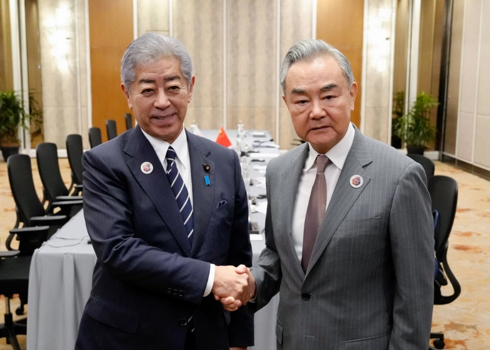 Foreign Minister Takeshi Iwaya (left) shakes hands with his Chinese counterpart, Wang Yi, during bilateral talks on the sidelines of Association of Southeast Asian Nations-related meetings in Kuala Lumpur on Thursday. Foreign Minister Takeshi Iwaya (left) shakes hands with his Chinese counterpart, Wang Yi, during bilateral talks on the sidelines of Association of Southeast Asian Nations-related meetings in Kuala Lumpur on Thursday.