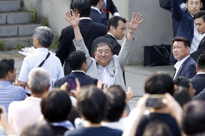 Prime Minister Shigeru Ishiba, who heads the ruling Liberal Democratic Party (center) waves to attendees as he departs after delivering a campaign speech in Yokohama on Sunday.  Prime Minister Shigeru Ishiba, who heads the ruling Liberal Democratic Party (center) waves to attendees as he departs after delivering a campaign speech in Yokohama on Sunday.
