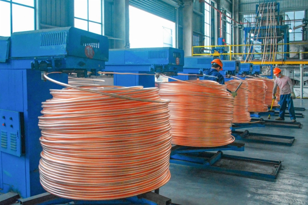 Copper rods are wound at a workshop that recycles the metal in Anqing, China, on Friday. Copper rods are wound at a workshop that recycles the metal in Anqing, China, on Friday.