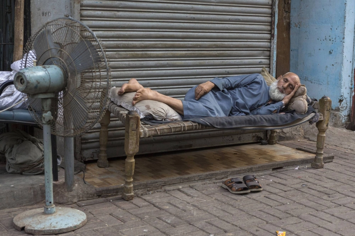 A man sleeps in front of a fan outdoors in Karachi, Pakistan, where many homes suffer from poor ventilation and a lack of cooling systems, on June 17. A man sleeps in front of a fan outdoors in Karachi, Pakistan, where many homes suffer from poor ventilation and a lack of cooling systems, on June 17.