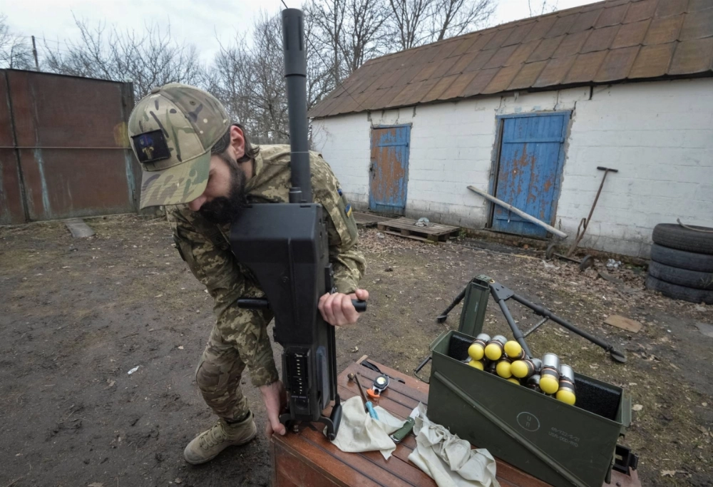 A serviceman of the 57th Separate Motorized Infantry Brigade of the Ukrainian Armed Forces works with an Mk 19 U.S.-made automatic grenade launcher near the front-line town of Vovchansk in Ukraine's Kharkiv region, on March 13. A serviceman of the 57th Separate Motorized Infantry Brigade of the Ukrainian Armed Forces works with an Mk 19 U.S.-made automatic grenade launcher near the front-line town of Vovchansk in Ukraine's Kharkiv region, on March 13.