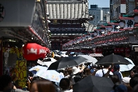 Visitors crowd Nakamise shopping street in the Asakusa district of Tokyo on June 22. | Bloomberg