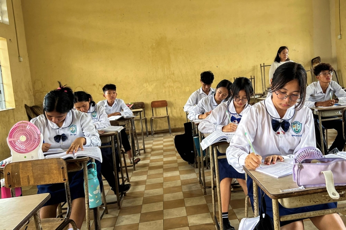 Students use fans to cool down during a class at a school in Phnom Penh in May last year.  Students use fans to cool down during a class at a school in Phnom Penh in May last year.
