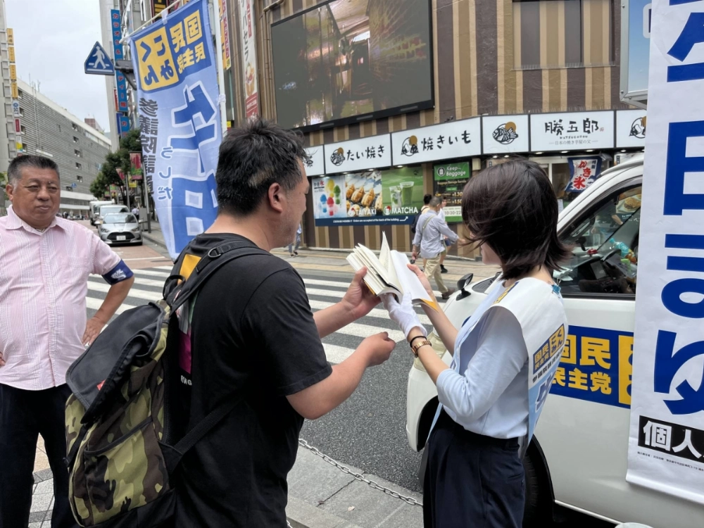 Mayu Ushida, a former NHK newscaster running for election in the Tokyo electoral district on the Democratic Party for the People ticket, signs an autograph for a voter after a public rally at Shinjuku Station in Tokyo on Tuesday. Mayu Ushida, a former NHK newscaster running for election in the Tokyo electoral district on the Democratic Party for the People ticket, signs an autograph for a voter after a public rally at Shinjuku Station in Tokyo on Tuesday.