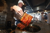 An employee at Yatsumeya Nishimura, an eel restaurant in Tokyo's Meguro Ward, grills eel on Saturday, this year's Day of Ox. | JIJI