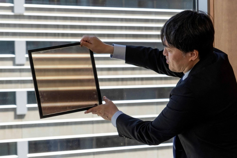Yukihiro Kaneko, Panasonic's research officer, shows a perovskite panel, through which the background can been seen, during an interview in Tokyo. Yukihiro Kaneko, Panasonic's research officer, shows a perovskite panel, through which the background can been seen, during an interview in Tokyo.