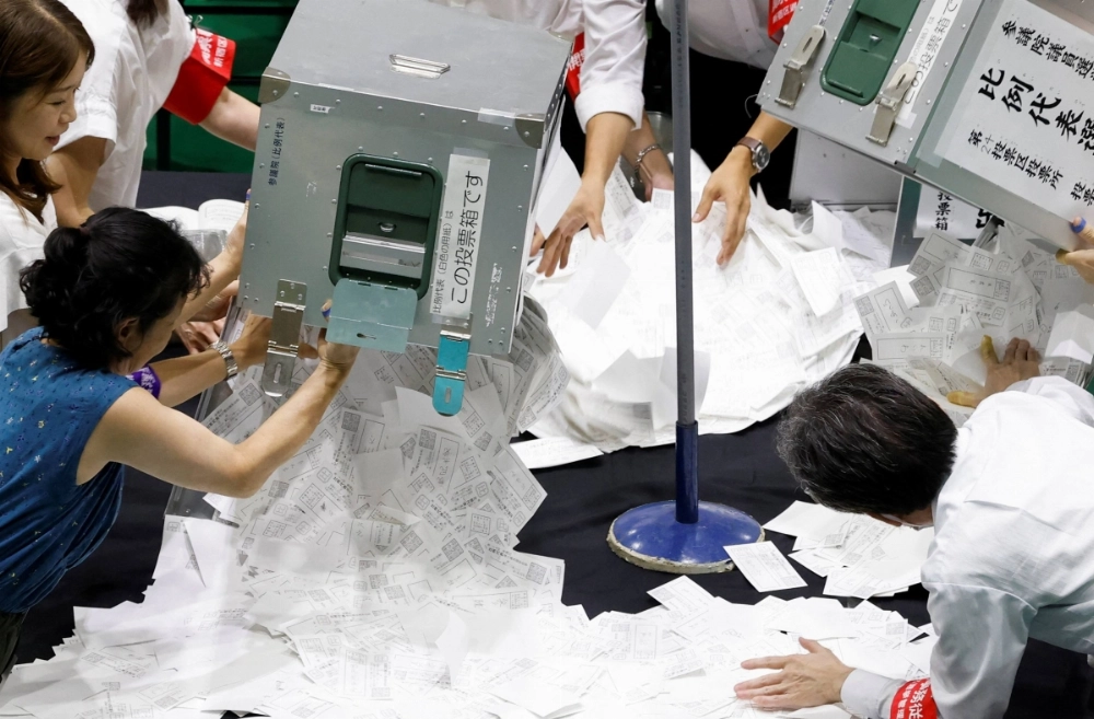 Election officials open ballot boxes during the Upper House election at a counting center in Tokyo on Sunday. Election officials open ballot boxes during the Upper House election at a counting center in Tokyo on Sunday.