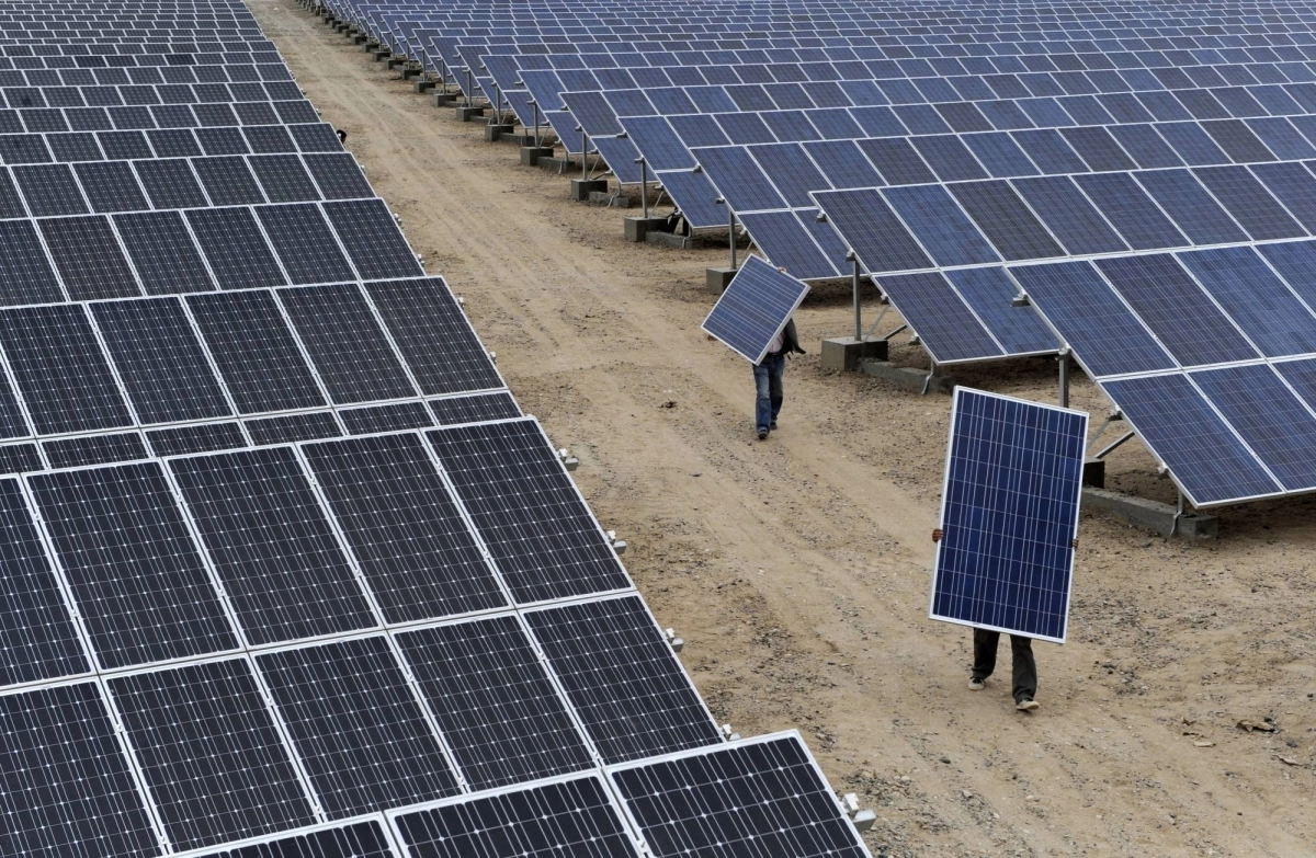 Employees carry solar panels at a plant in Aksu in China's Xinjiang Uyghur Autonomous Region in 2012. Employees carry solar panels at a plant in Aksu in China's Xinjiang Uyghur Autonomous Region in 2012.