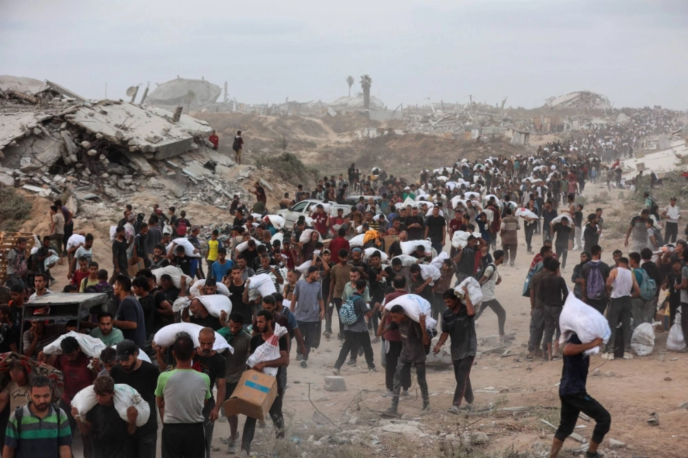 Palestinians crowd a coastal path west of the city of Beit Lahia in the Gaza Strip after managing to get aid parcels on Tuesday. Palestinians crowd a coastal path west of the city of Beit Lahia in the Gaza Strip after managing to get aid parcels on Tuesday.
