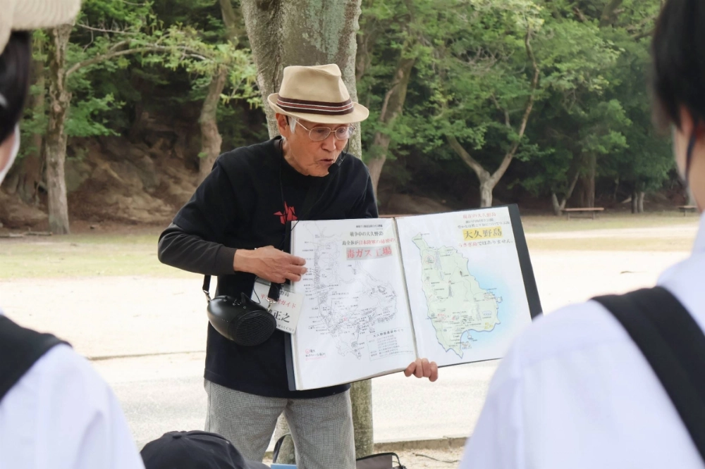 Masayuki Yamauchi teaches junior high school students about the history of Okunoshima, an island in Takehara, Hiroshima Prefecture, in May. Masayuki Yamauchi teaches junior high school students about the history of Okunoshima, an island in Takehara, Hiroshima Prefecture, in May.