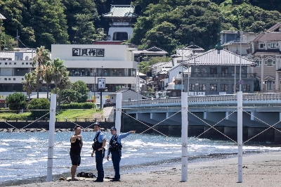 Police officers ask a man to evacuate from an empty beach following a tsunami warning, in Fujisawa, Kanagawa Prefecture, on Wednesday. Police officers ask a man to evacuate from an empty beach following a tsunami warning, in Fujisawa, Kanagawa Prefecture, on Wednesday.