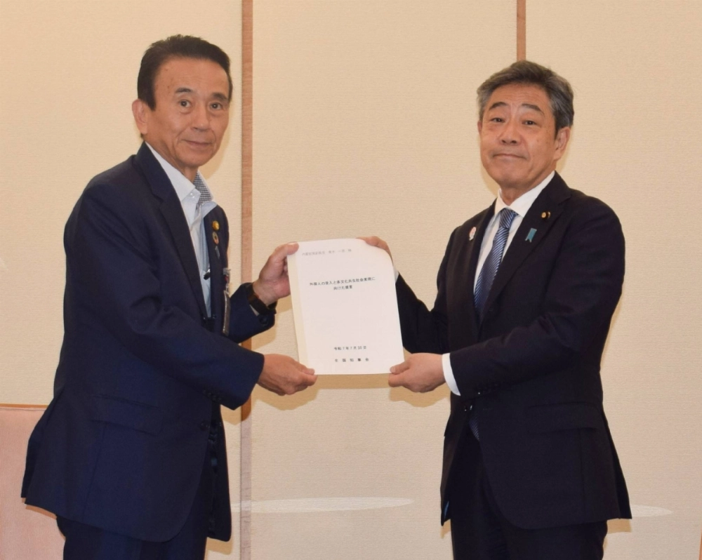 Shizuoka Gov. Yasutomo Suzuki (left) hands a proposal to promote a multicultural society to Deputy Chief Cabinet Secretary Kazuhiko Aoki on Wednesday in Tokyo.  Shizuoka Gov. Yasutomo Suzuki (left) hands a proposal to promote a multicultural society to Deputy Chief Cabinet Secretary Kazuhiko Aoki on Wednesday in Tokyo.