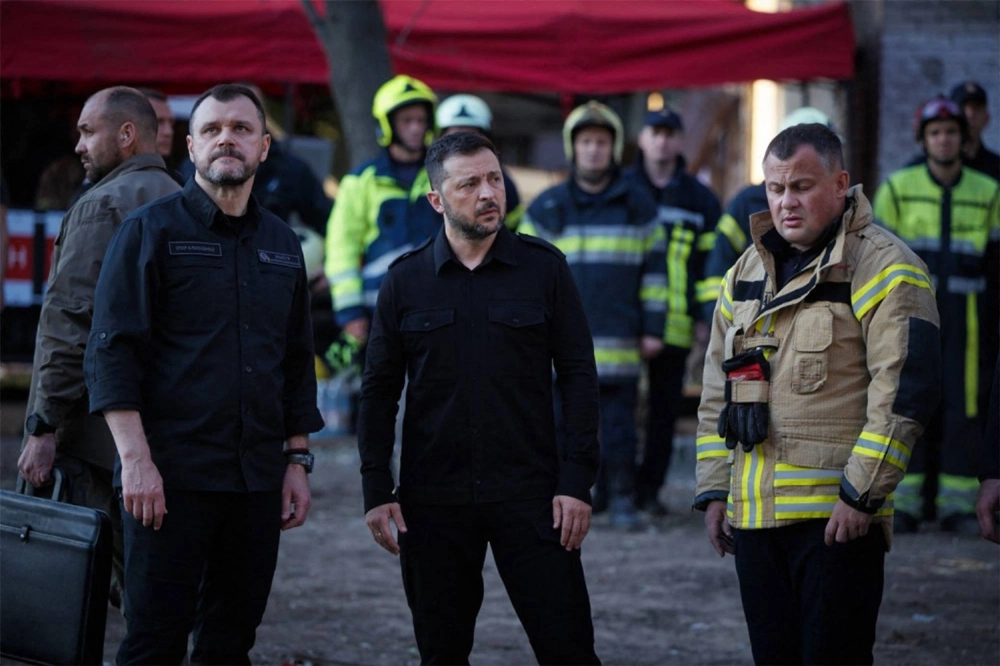 Ukrainian President Volodymyr Zelenskyy talks with rescuers Friday at a residential building in Kyiv that was partially destroyed due to a Russian missile. Ukrainian President Volodymyr Zelenskyy talks with rescuers Friday at a residential building in Kyiv that was partially destroyed due to a Russian missile.