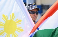 An Indian Naval officer stands behind Philippine and Indian flags at the international port of Manila on Friday. India's naval vessels arrived in Manila for a port visit late last week. | AFP-JIJI